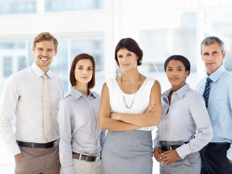 Diverse group of five professionals standing together in a bright office