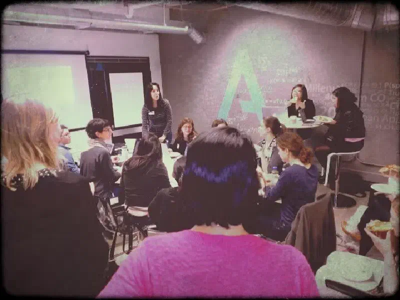 An early R-Ladies San Francisco meetup in January 2014, with members gathered around a table for a presentation